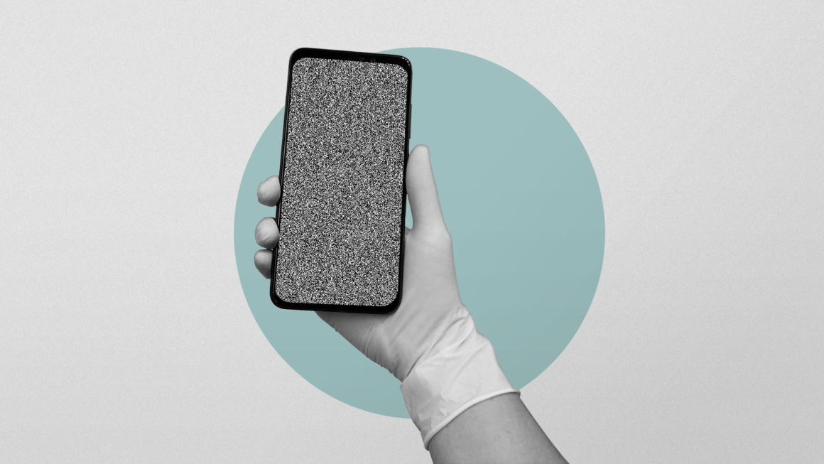 Mão com uma luva usada em cirurgia segura um celular, com a tela chuviscada.